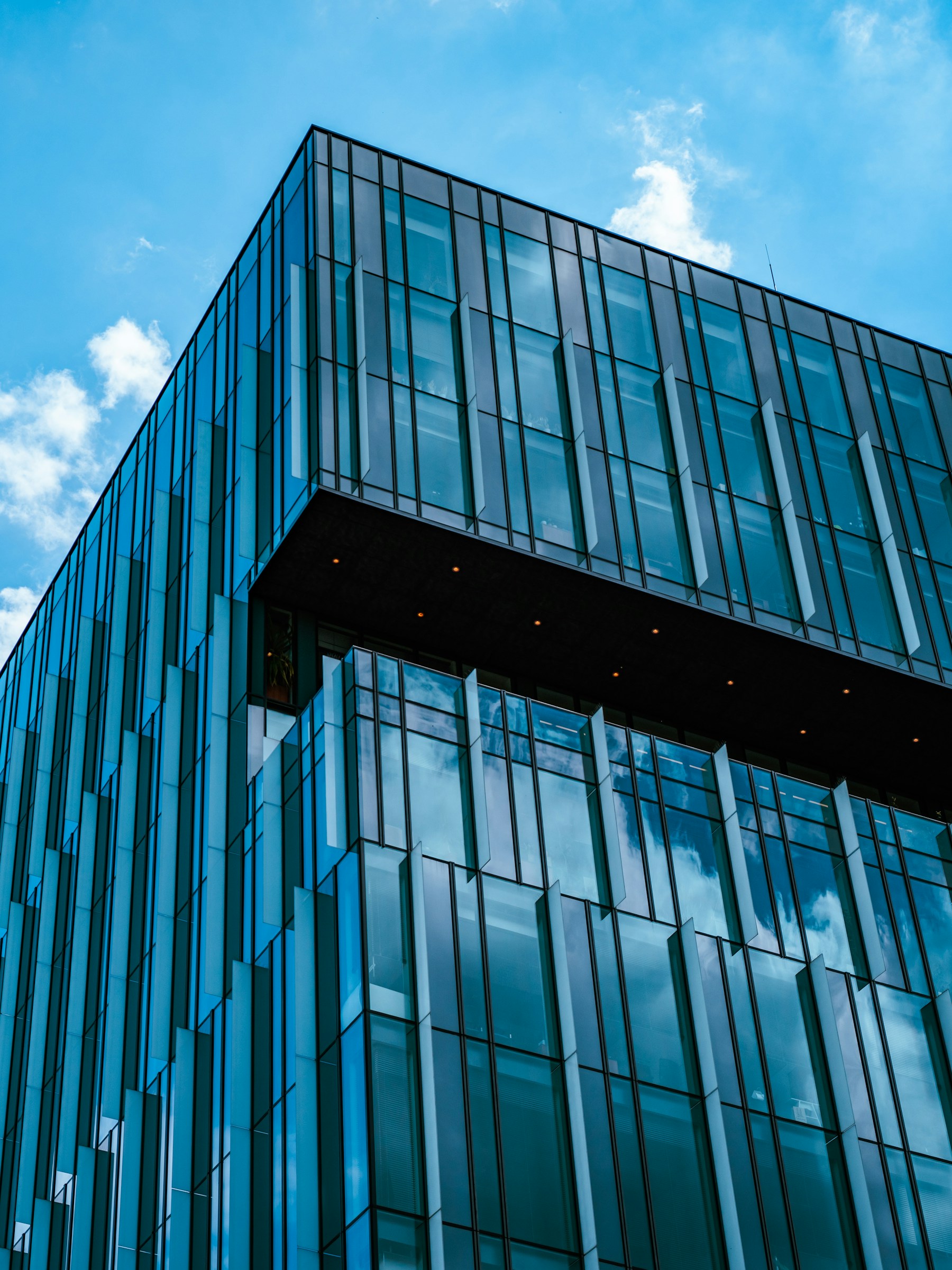 Clean lines of a glass office tower against a blue sky